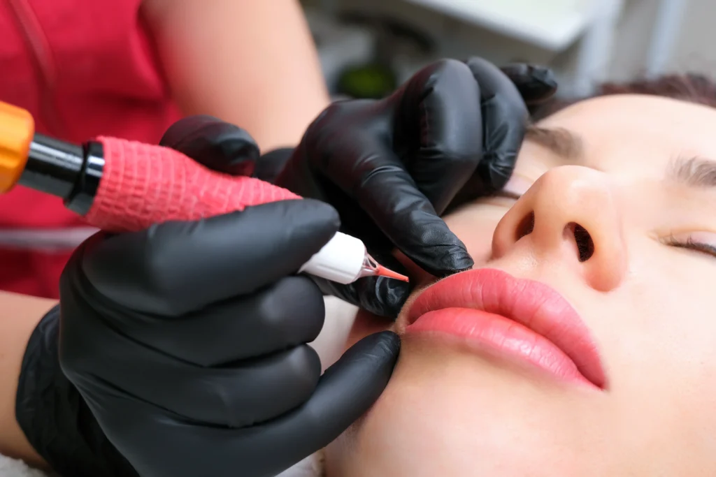 The image shows a close-up of a cosmetic procedure where a professional is carefully enhance or correct the natural lip color.