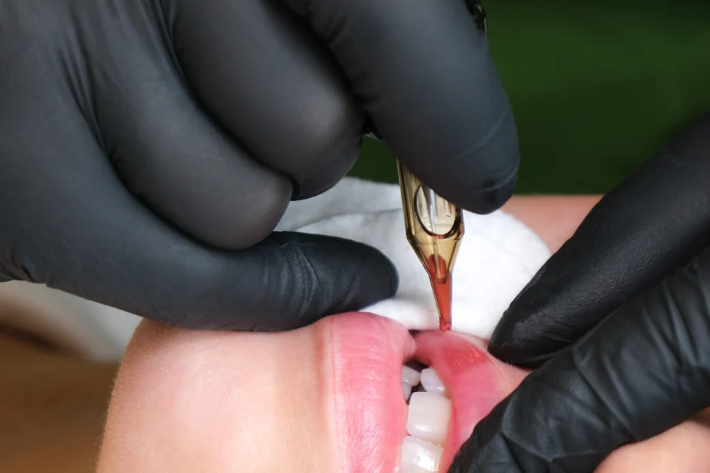 The image shows a close-up of a procedure where a person’s lips are being microbladed.