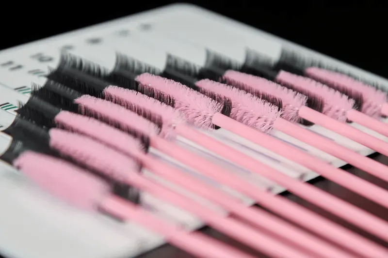 The image displays an array of eyelash extensions organized with precision, highlighting the variety of styles available.