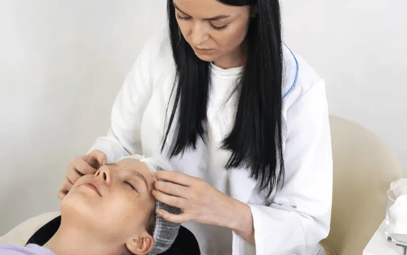 This image depicts a professional performing a lash lift procedure