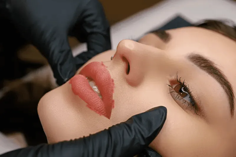 The image shows the application of a lip liner tattoo